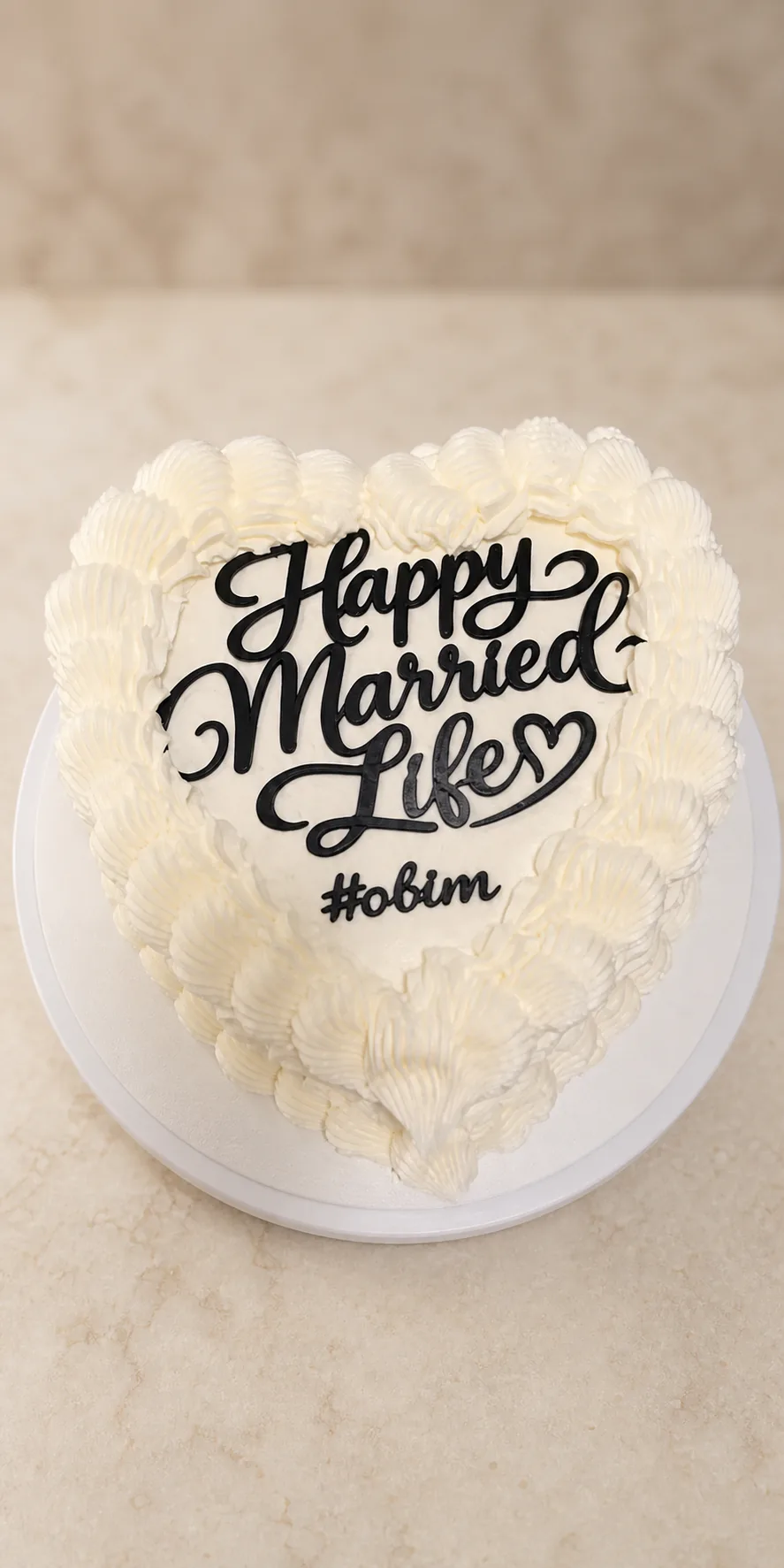 Black Happy Married Life cake topper on a heart shaped cake